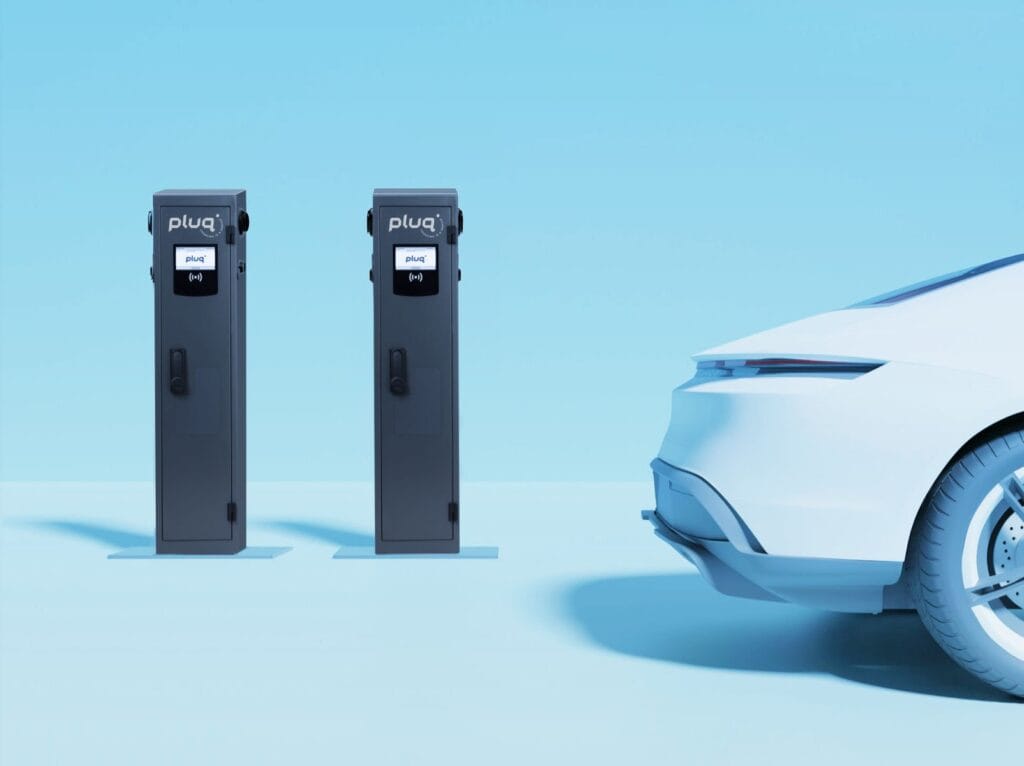 A partial view of a white electric car charging near two black electric vehicle charging stations against a light blue background.
